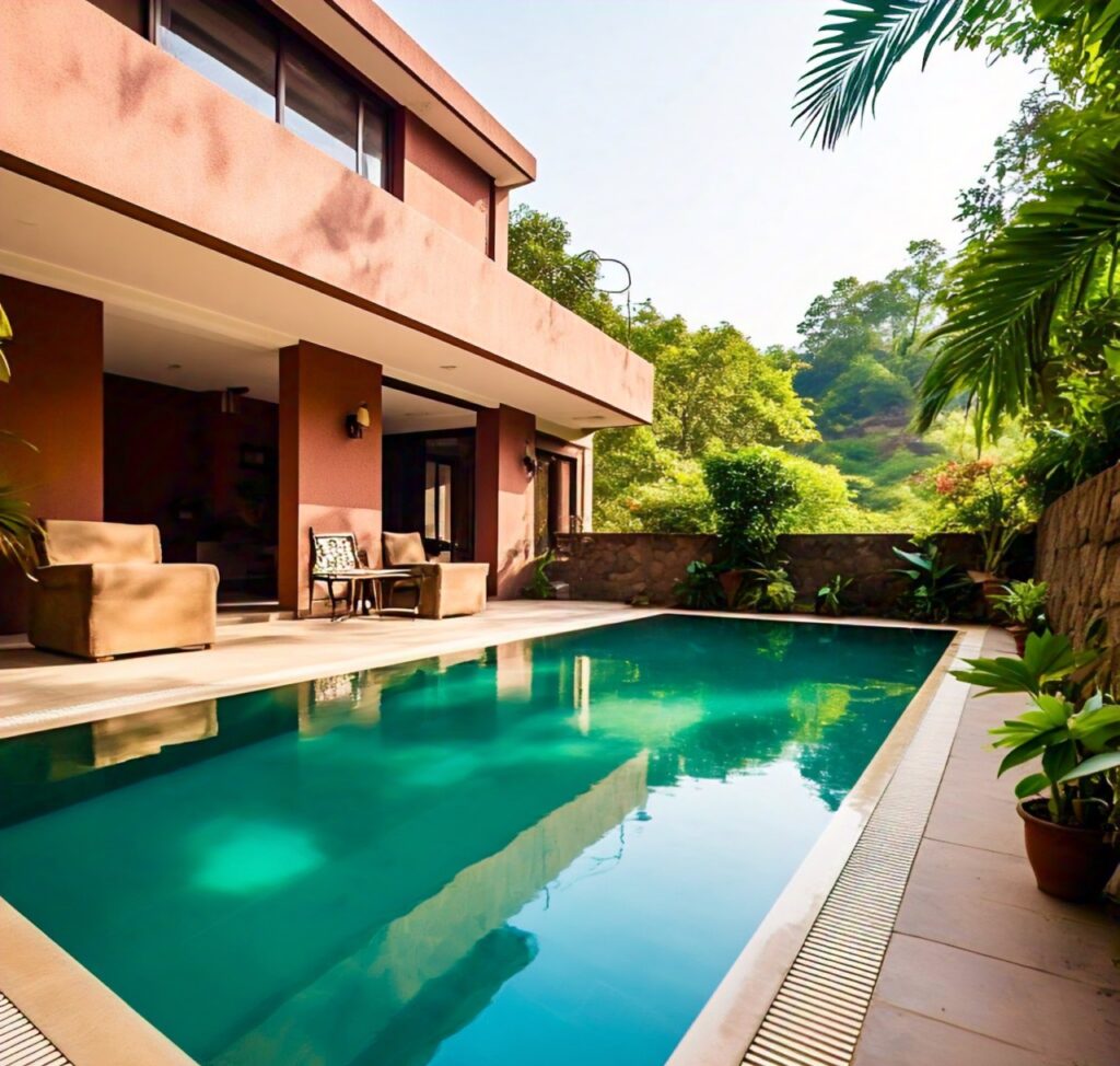 Luxury poolside villa in Lonavala featuring turquoise infinity pool, comfortable outdoor seating, and lush tropical landscaping with mountain views